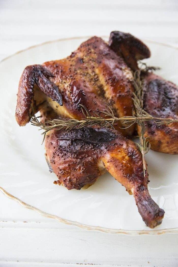 Honey Mustard Whole Chicken in White Plate with Rosemary Sprigs