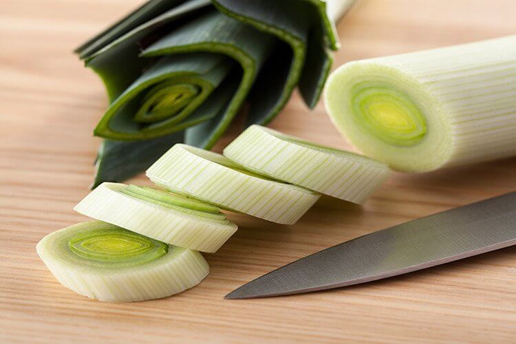 cleaning and chopping leeks in a board