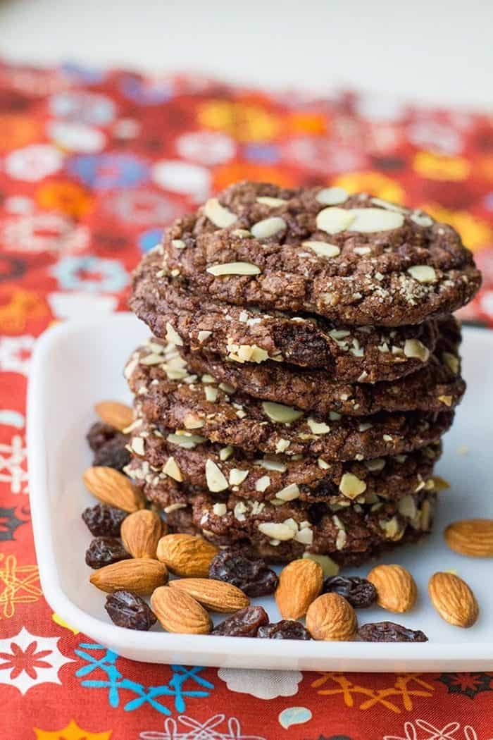 close up Old Fashioned Chewy Chocolate Raisin Cookies in a white plate with almonds and raisins