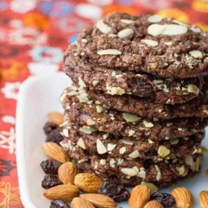 close up Old Fashioned Chewy Chocolate Raisin Cookies in a white plate with almonds and raisins