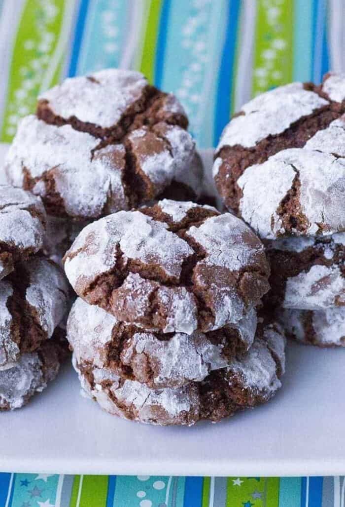 close up stacks of Classic Chocolate Crinkle Cookies in a white plate