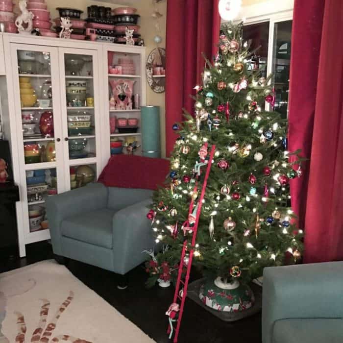 Christmas tree with vintage ornaments in the middle of two couches