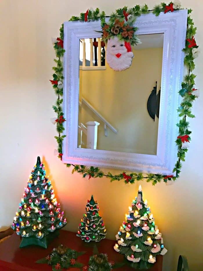 plastic and felt Santa decor in a wall mirror with white frame