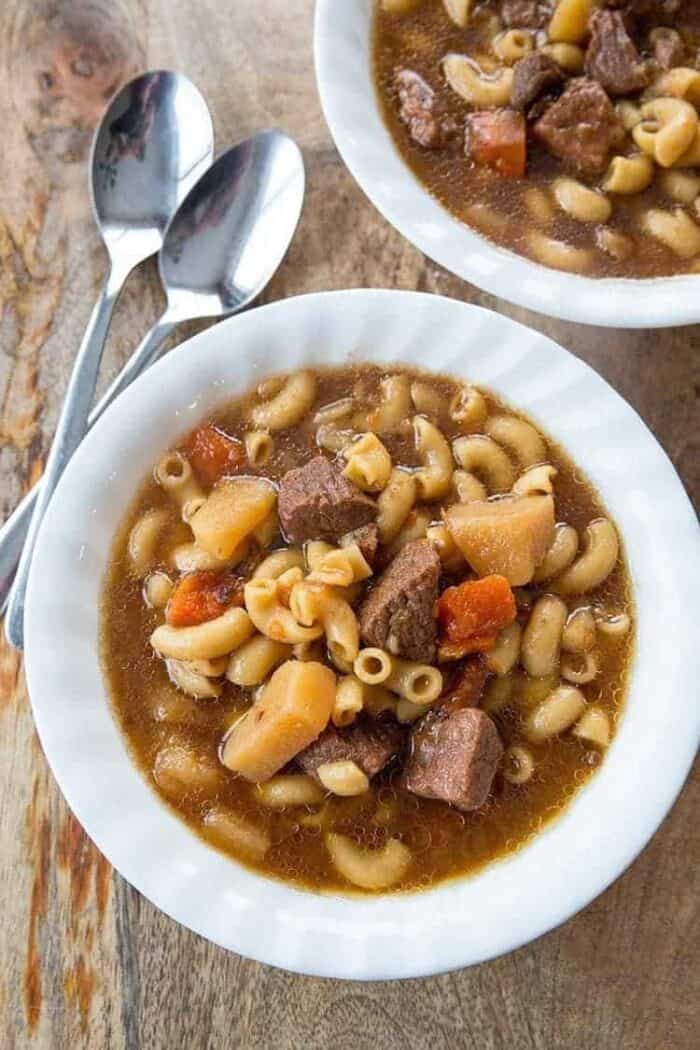 Top down shot of Beef Macaroni Soup in beef broth based on wood background