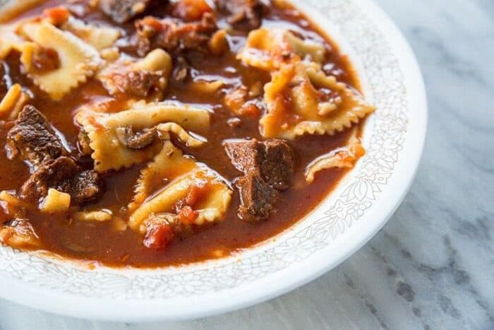 Beefy Pasta Puttanesca Soup Topped with Sprinkle of Parmesan Cheese