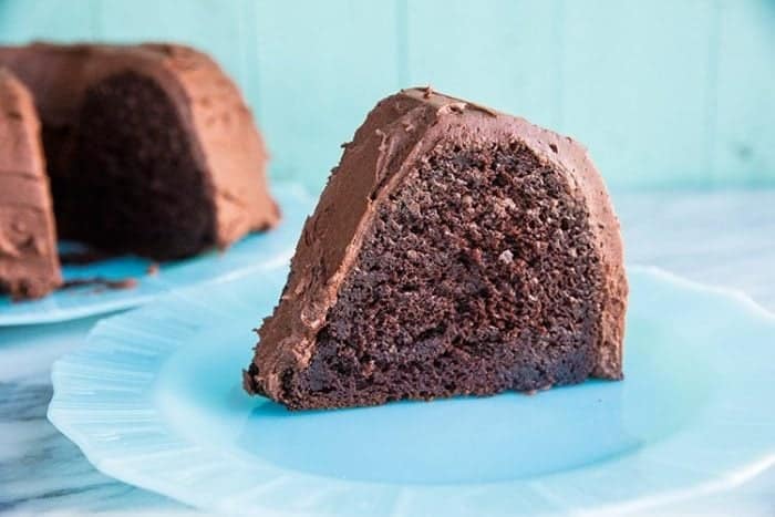 Close up of Chocolate Avocado Bundt Cake Slice with Chocolate Icing in a White Plate