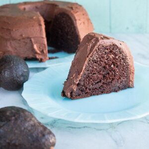Chocolate Avocado Bundt Cake with Chocolate Icing, Two Pieces of Avocado Fruits on the Side