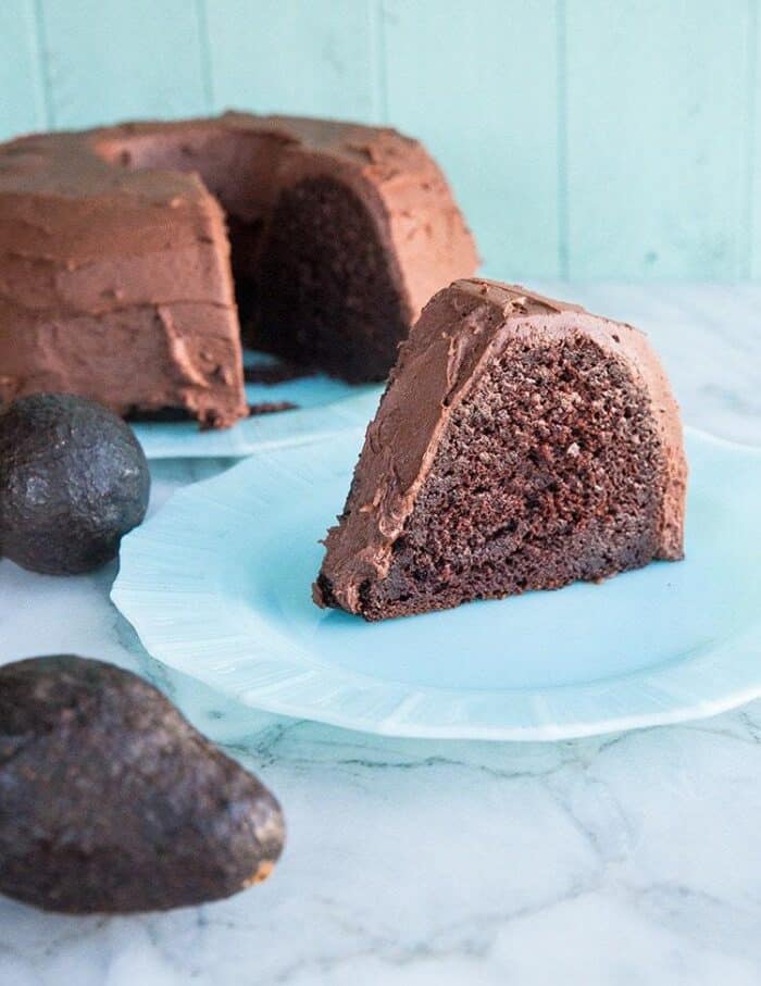 Chocolate Avocado Bundt Cake with Chocolate Icing, Two Pieces of Avocado Fruits on the Side