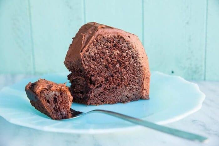 Slice of Chocolate Avocado Bundt Cake Frost with Chocolate Icing in a White Plate