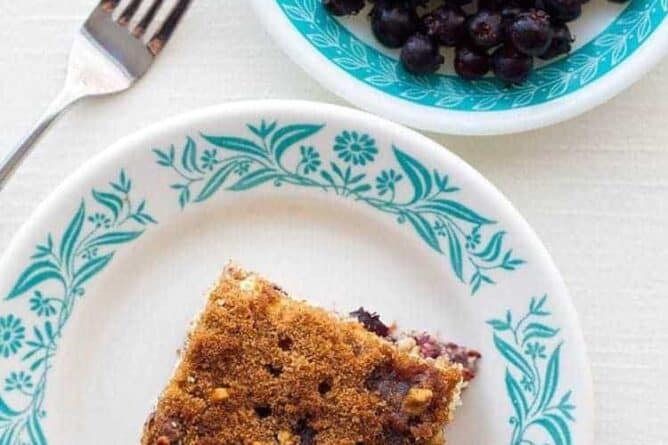 top down shot of Saskatoon Coffee Cake slice and blueberries on small plates