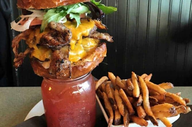 Bacon Double Alberta Beef Burger on top of a Bacon Caesar with fries on the side