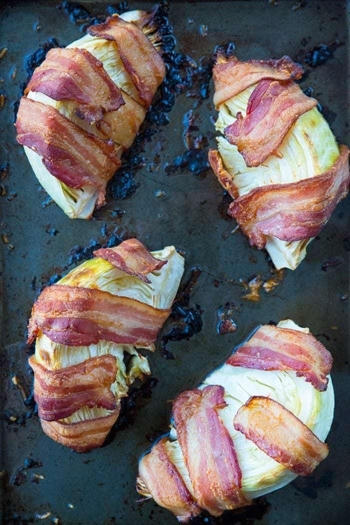 close up of Bacon Wrapped Roasted Cabbage Wedges in a large baking sheet