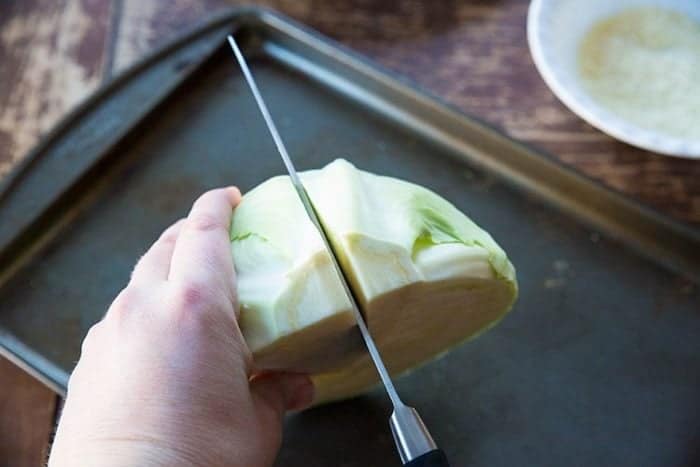 cutting the a half cabbage into another half 