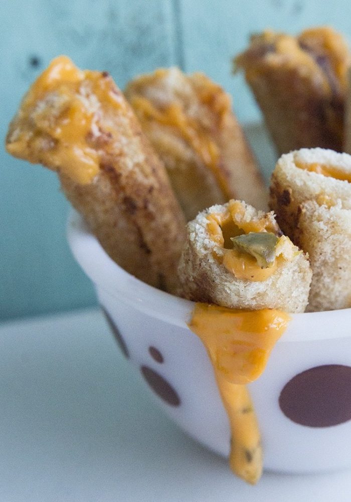 grilled cheese rollups in a bowl with melty and gooey cheese