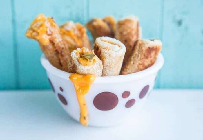  Jalapeno Grilled Cheese Rollups in a White Pyrex bowl with Circle prints