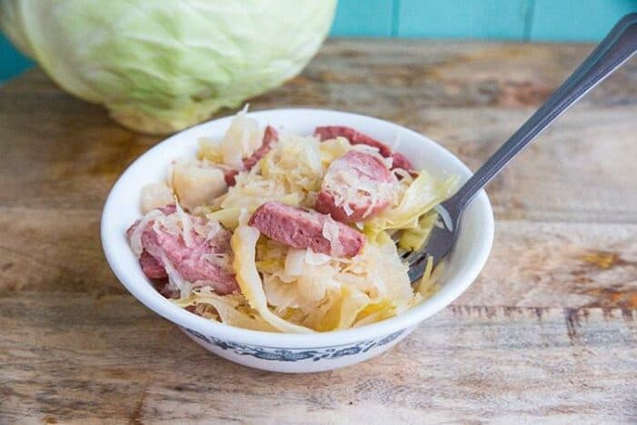 Kielbasa Kapusta in a small white bowl with fork in it