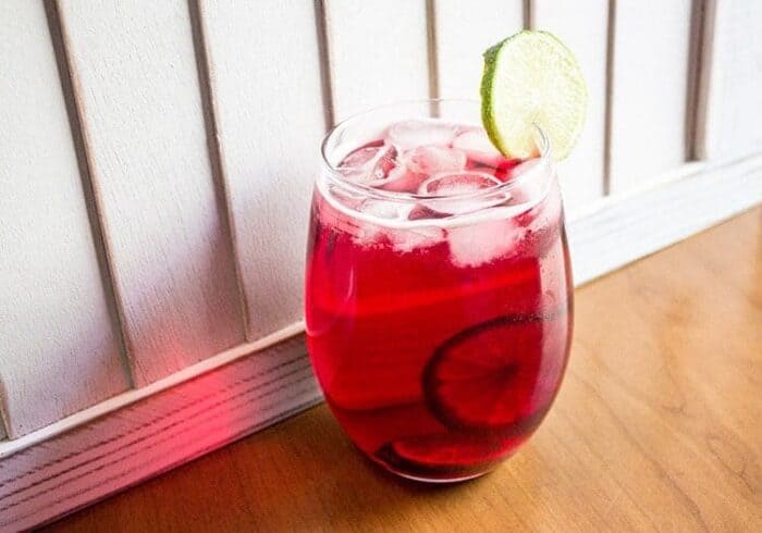 A Glass of Cranberry Zombie Drink with Slices of Lime