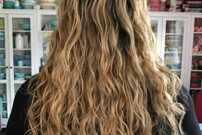 woman showing her long curly dark blonde hair hair