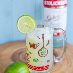 Classic Moscow Mule Recipe in a Vintage Hazel Atlas Glass, garnish with a slice of lime and a bottle of vodka on background
