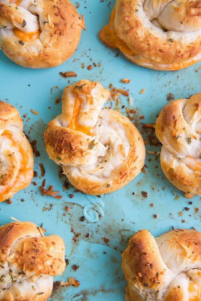 Top down shot of Cheese Stuffed Garlic Knots on jade blue background