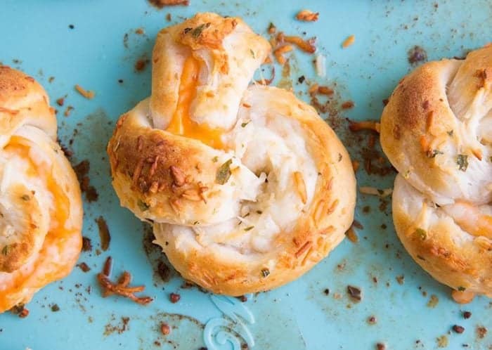 Close up Cheese Stuffed Garlic Knots on jade blue background