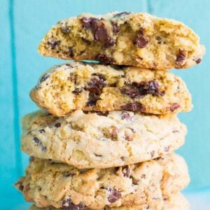 Close up Stack of Walnut Loaded Chunky Chocolate Chip Cookies in Ruffle Plate on Blue Background