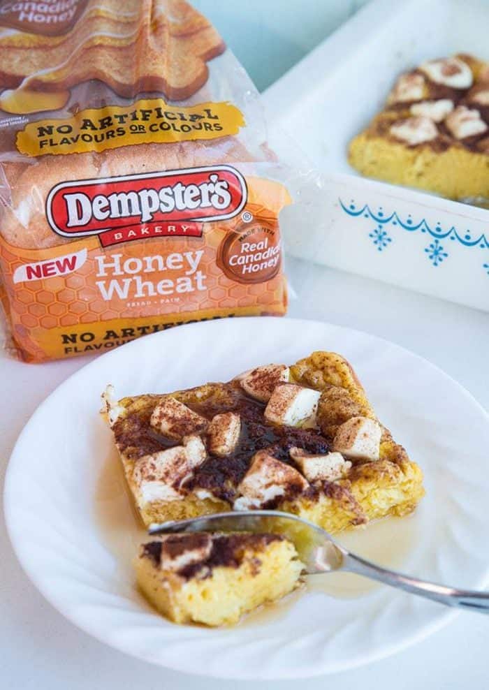 A slice of Cinnamon Maple Cream Cheese Baked French Toast and a Pack of Dempster's brand Honey Wheat bread