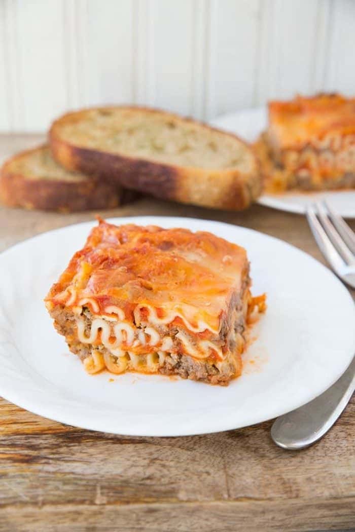 a serving of Mom's Cottage Cheese Lasagna, slices of bread toast on background