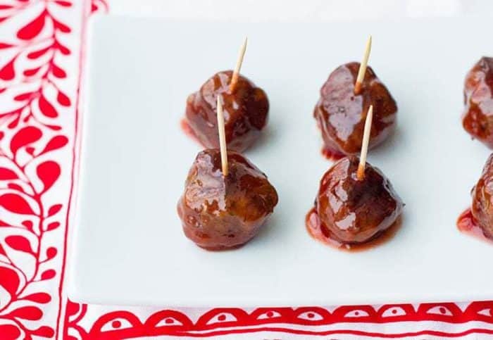 Grape Jelly Meatballs with pick in a white plate with red prints