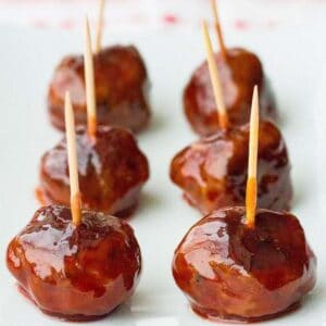 Six pieces of grape jelly meatball appetizers in a white plate