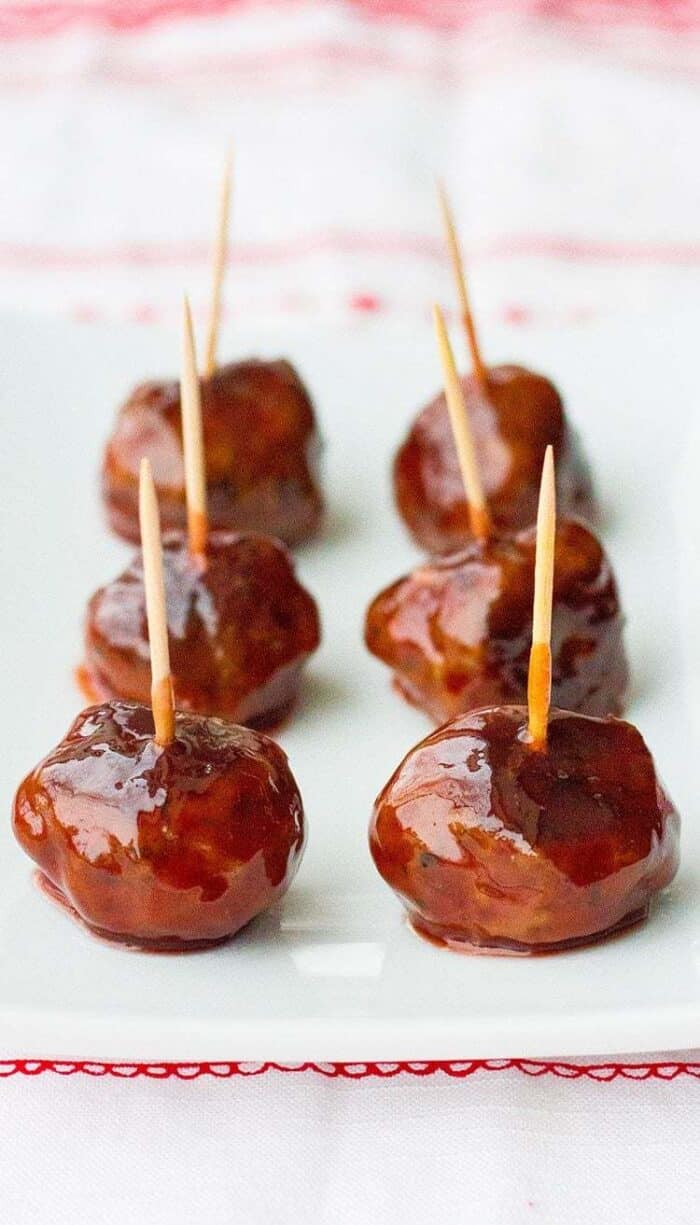 Six pieces of grape jelly meatball appetizers in a white plate