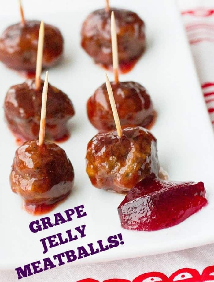 grape jelly meatballs with toothpicks on a white plate