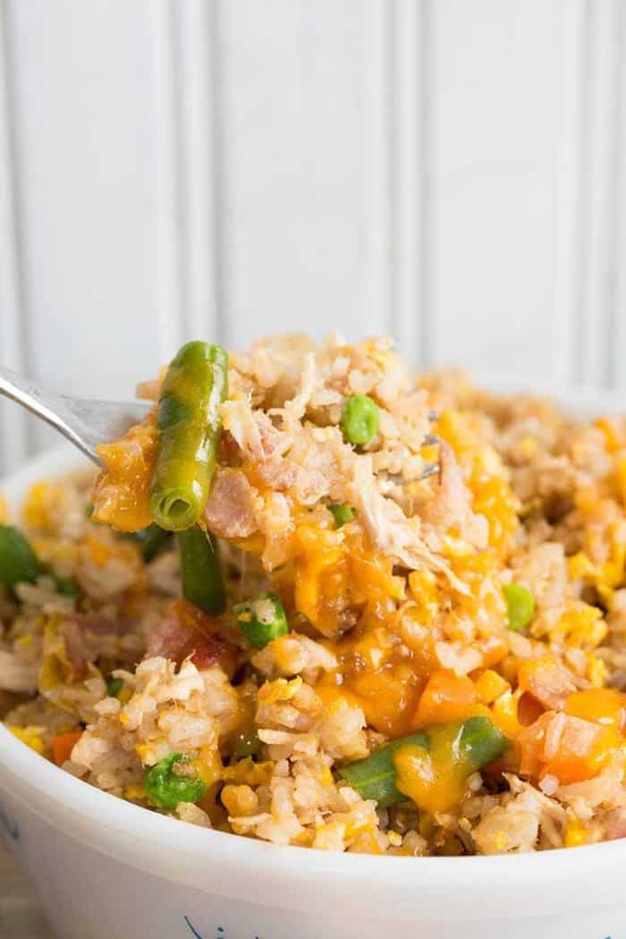 Close up of Fried Rice and vegetables in a fork on white background