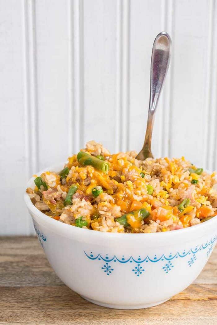 Fried Rice in a white bowl with spoon in it ready to be enjoy!