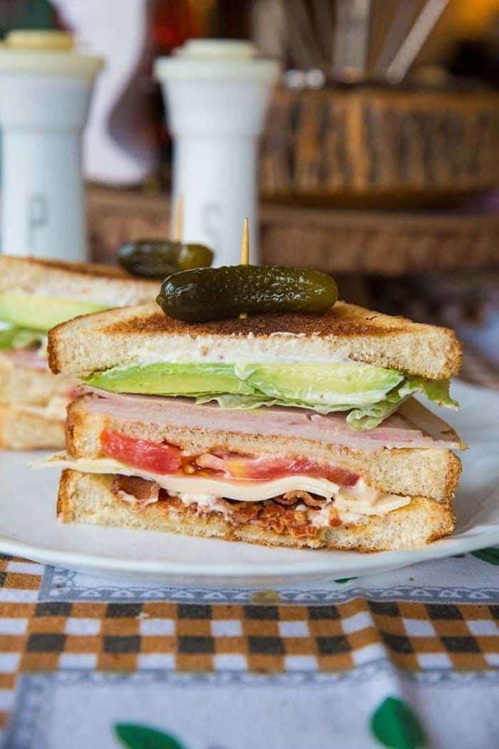 close up of Clubhouse Sandwich topped with Gherkins pickles