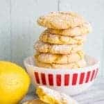 White printed bowl with stack of Cake Mix Cookies sprinkled with powdered sugar