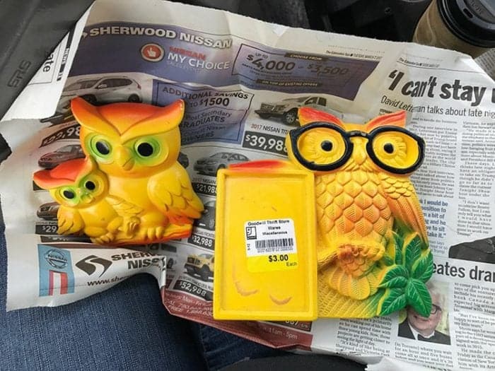 two pieces of Chalkware yellow colored owls on old news paper page