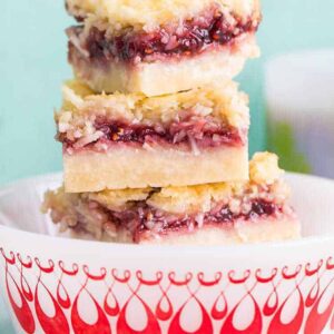 close up stack of Raspberry Coconut Bars in a white bowl