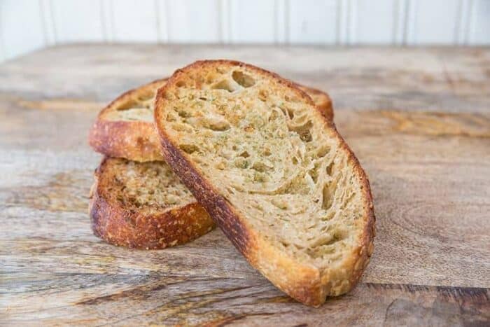 Slices of Homemade Garlic Bread Using Sourdough in wood background