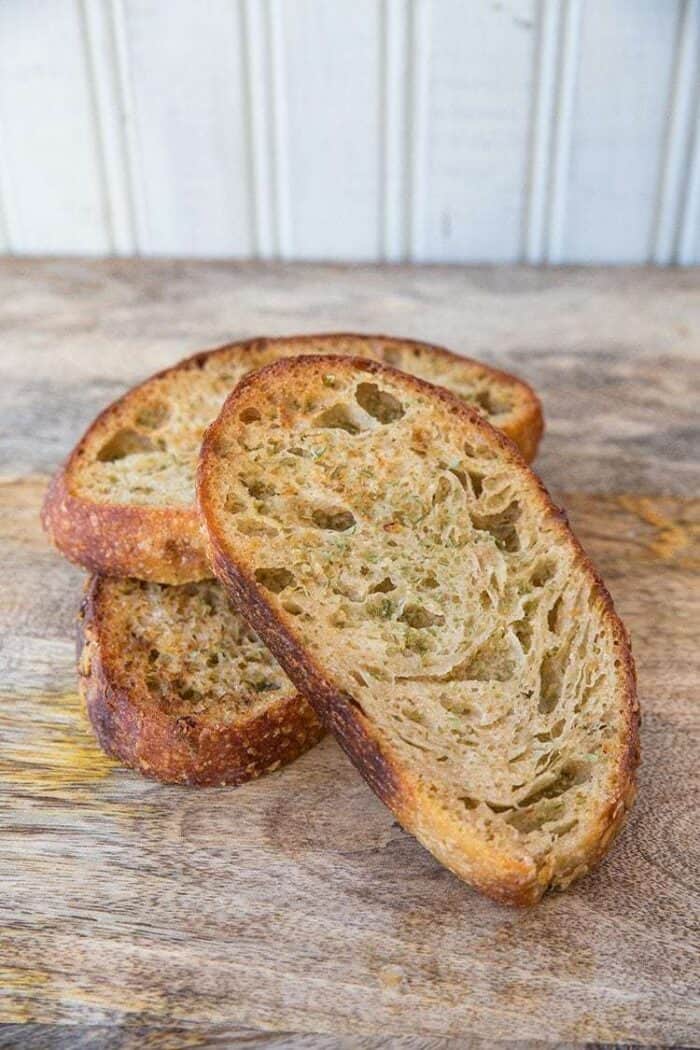 Close up Slices of Homemade Garlic Bread Using Sourdough in wood background