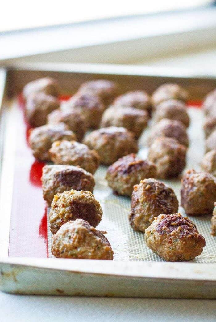 Close up of Rolled meatballs on a baking sheet