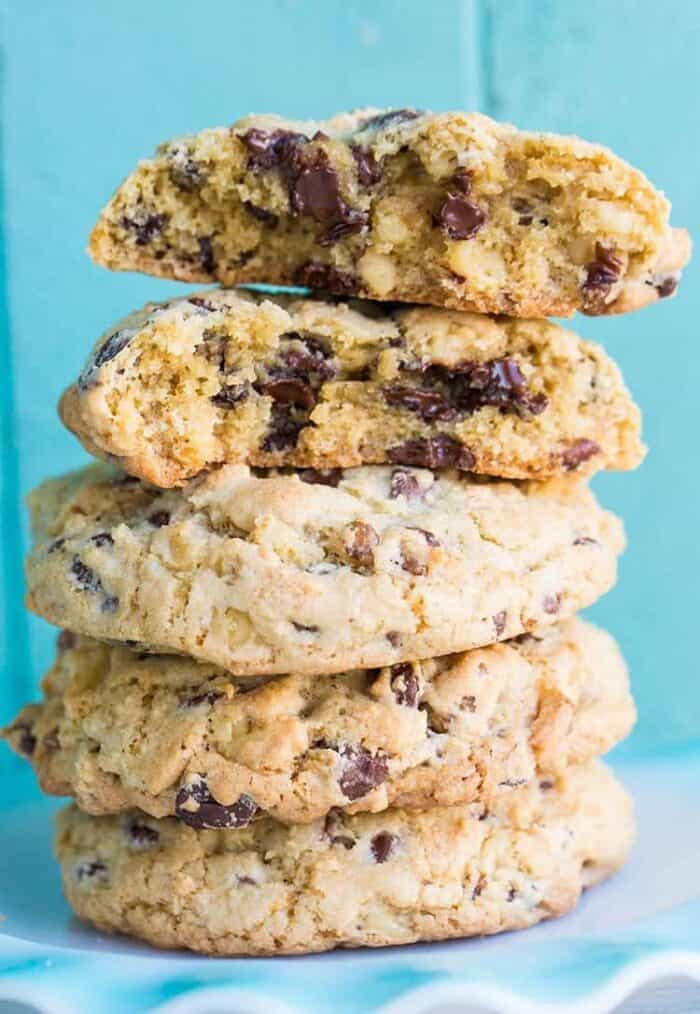 Close up Stack of Walnut Loaded Chunky Chocolate Chip Cookies in Ruffle Plate on Blue Background