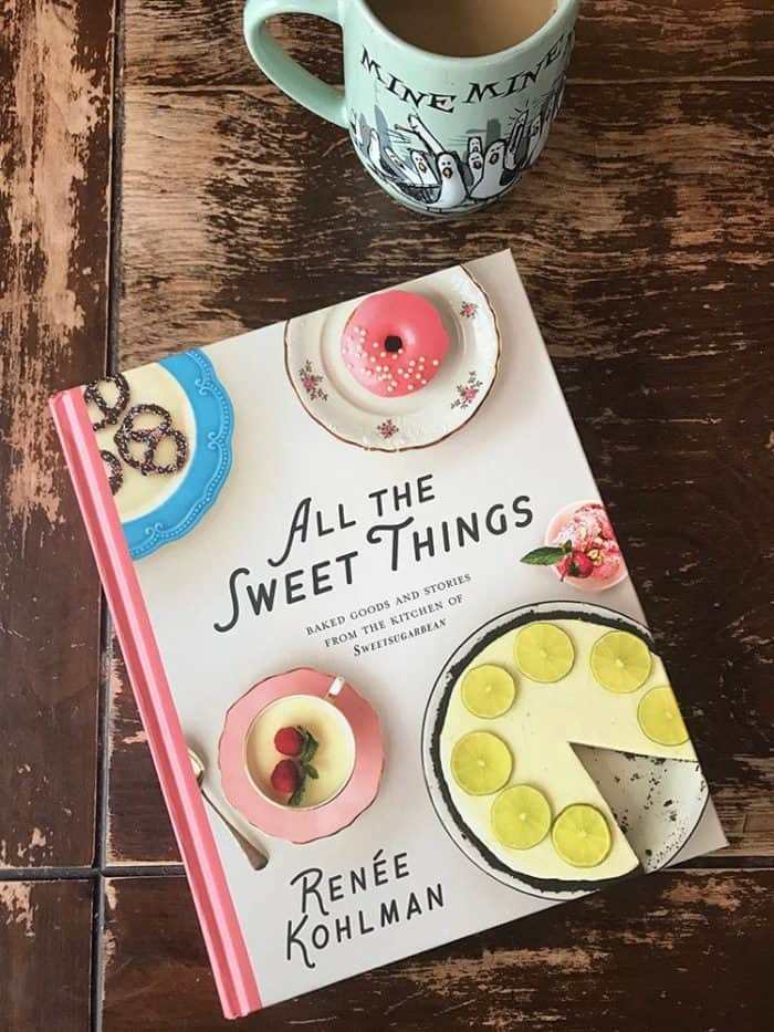 Top down shot of a cookbook by Renée Kolhman and a jade green mug on wood background