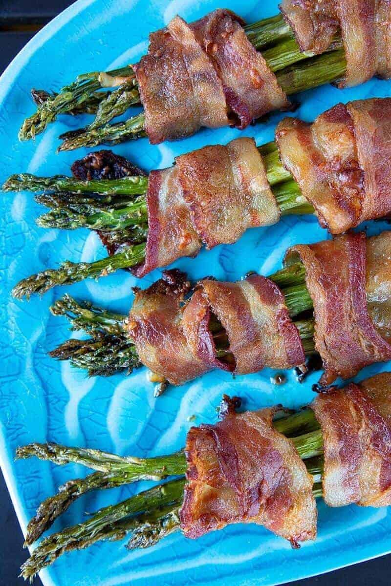 Close up of Bacon Wrapped Asparagus Bundles on a blue plate