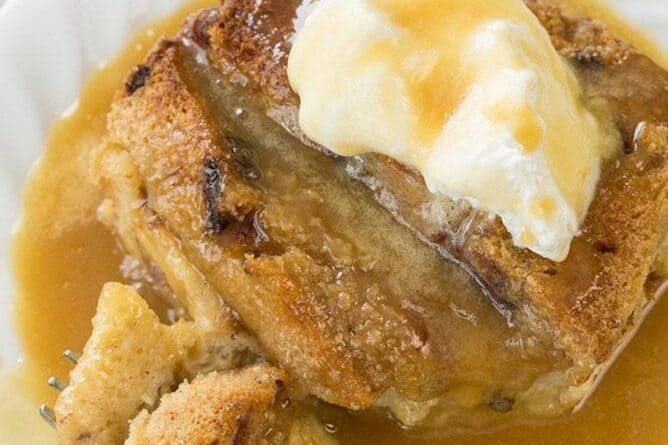 slices of Bread and Butter Pudding with caramel sauce in a white plate on marble background