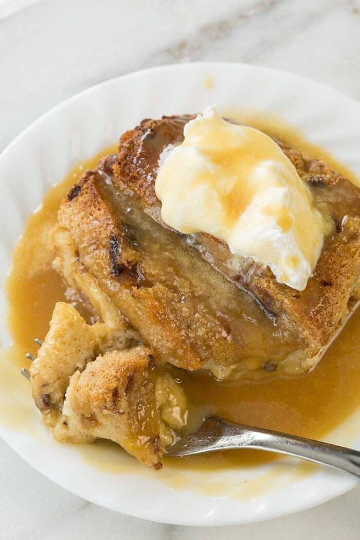 slices of Bread and Butter Pudding with caramel sauce in a white plate on marble background