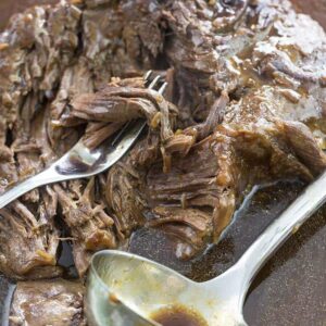 A fork and ladle soup spoon in Instant Pot Roast with gravy