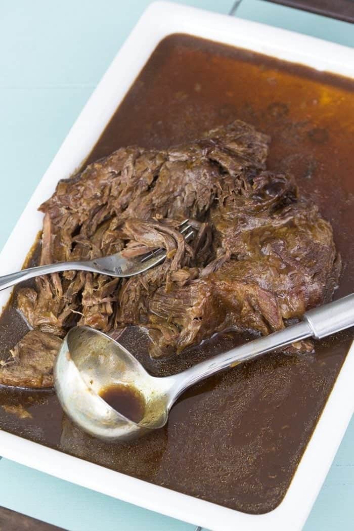 A fork and ladle soup spoon in Instant Pot Roast with Gravy ready to be enjoy!