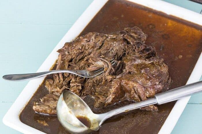 A fork and ladle soup spoon in Instant Pot Roast with gravy