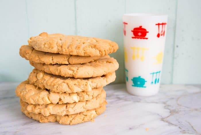 Stack of Double Peanut Butter & White Chocolate Chunk Cookies, white printed tumbler on the back